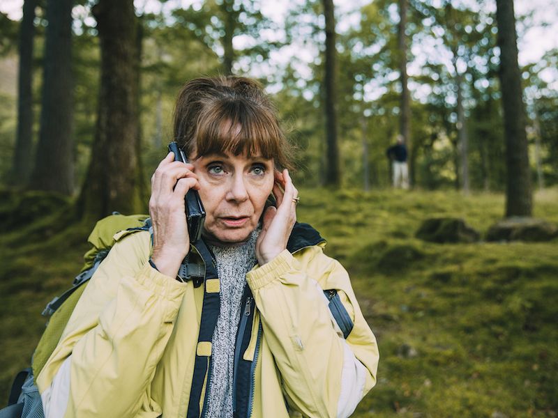 Woman suffering from hearing loss struggling to hear on the phone.