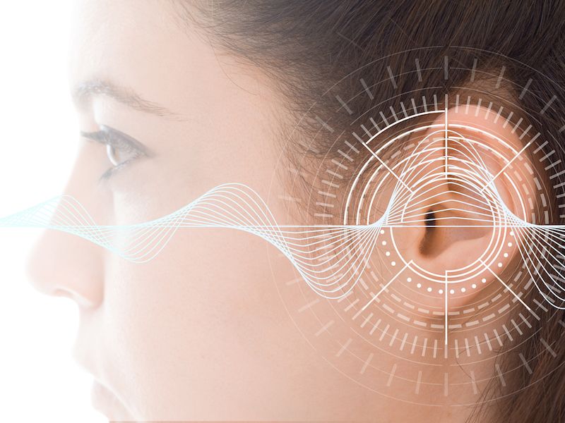 Image of woman getting hearing test with the results superimposed.